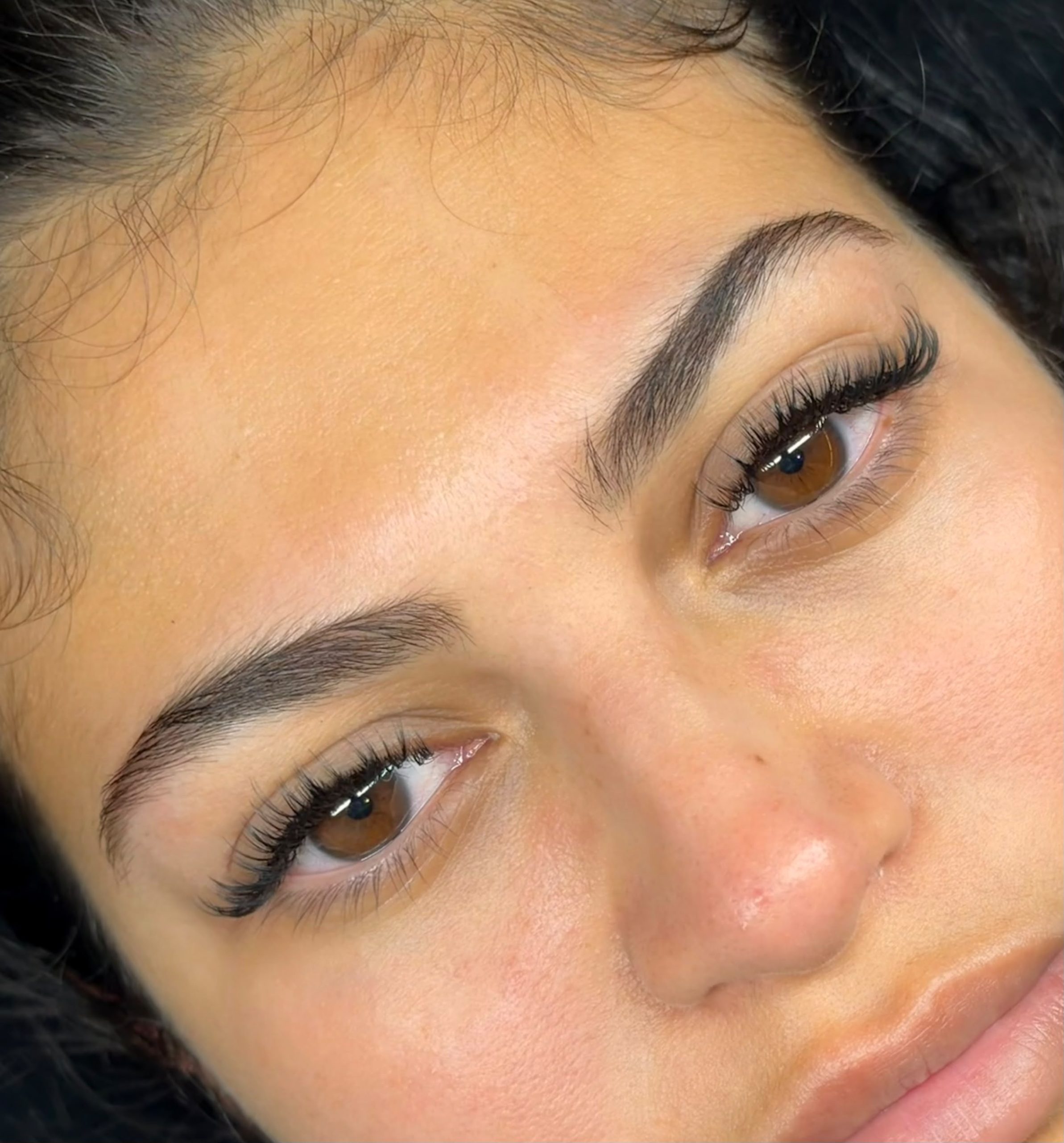 Flirty Studios client showing finished lash extensions on both eyes.