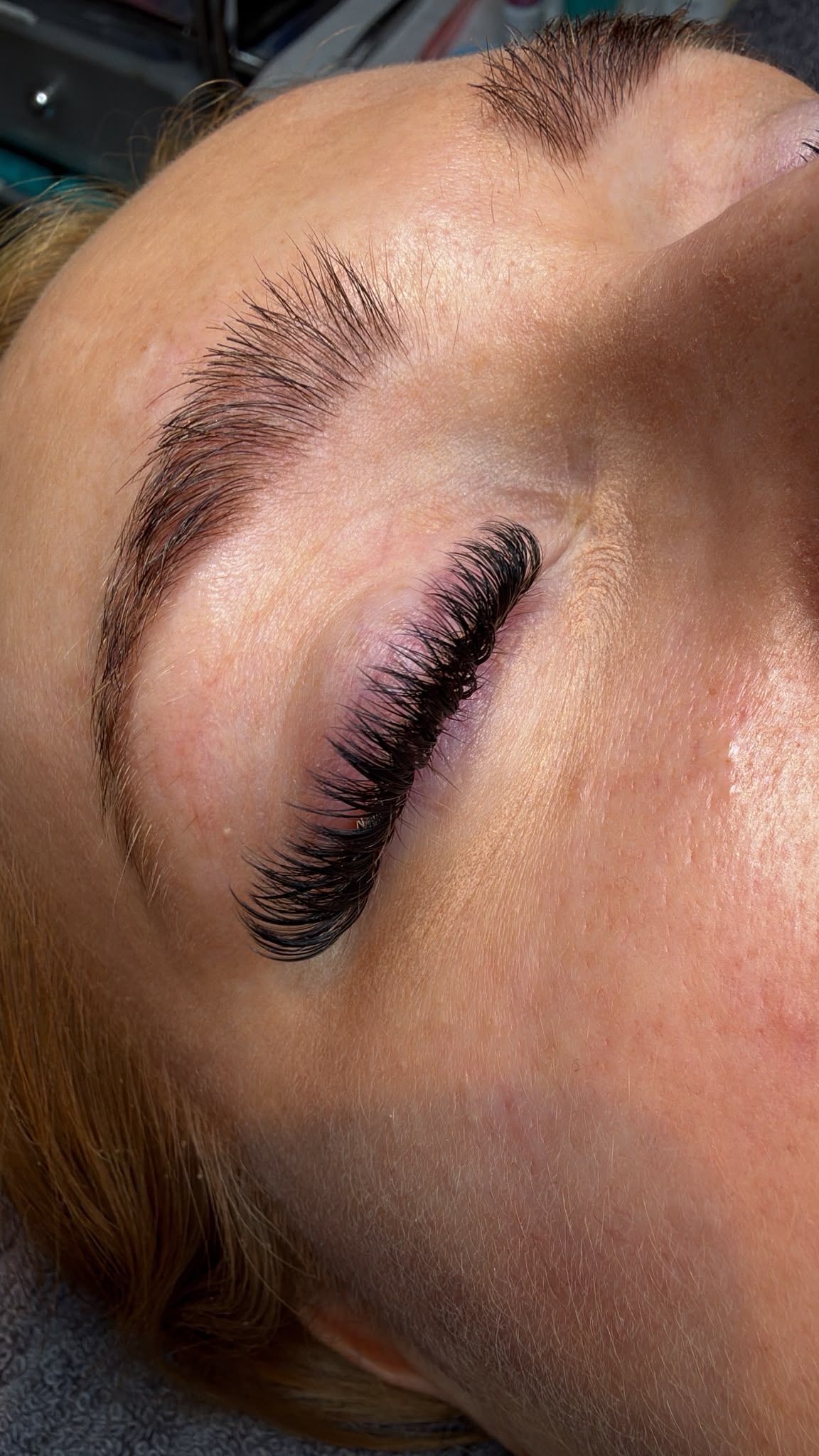 Close-up of finished lash extensions with the client’s eye closed at Flirty Studios.